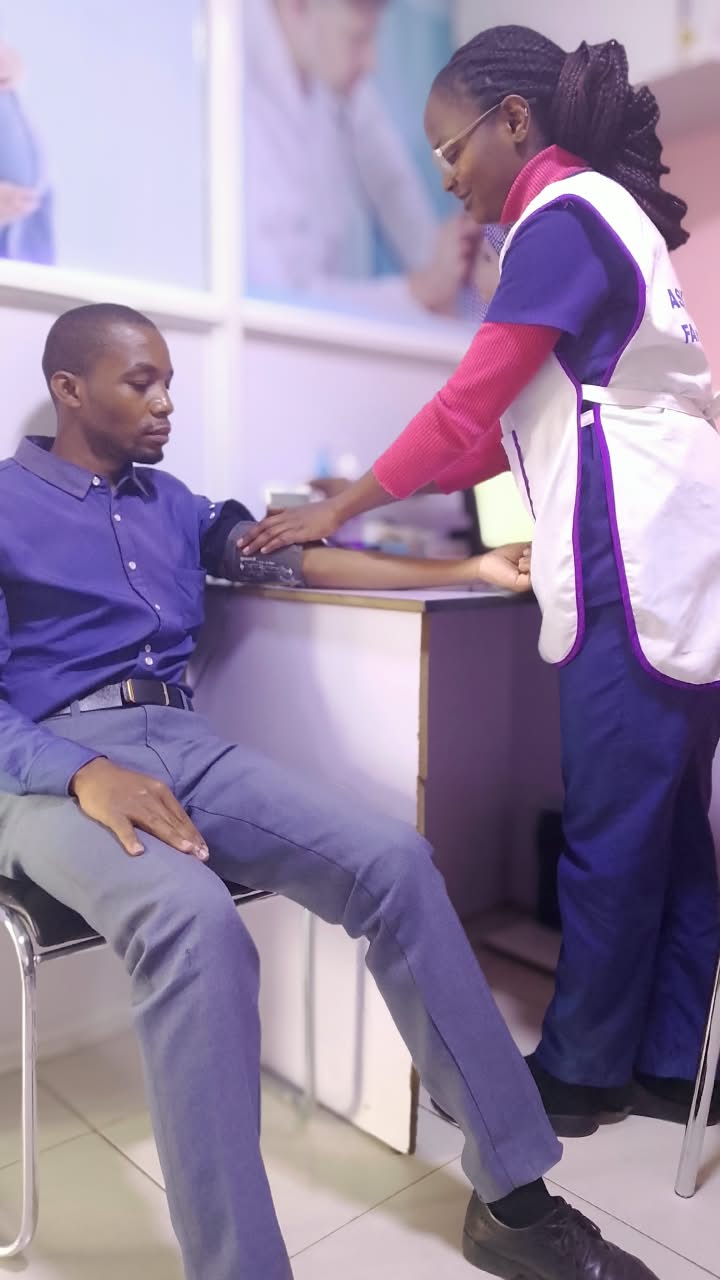 A nurse taking a patient's blood pressure in the consultation room